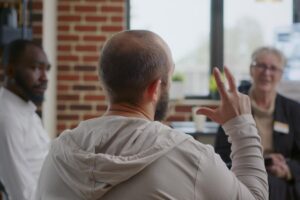 a man talking in a group therapy session demonstrating one of the many benefits of outpatient mental health treatment