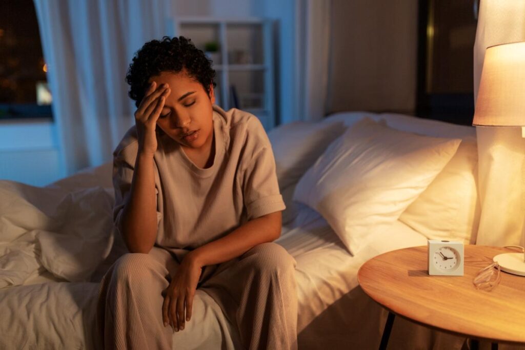 a woman in her bed waking up in pain and possibly showing signs of alcohol poisoning