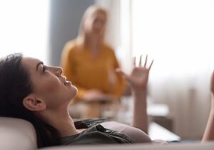 a woman sits on a couch discussing her thoughts and feelings to her therapist while participating in her cocaine addiction treatment program