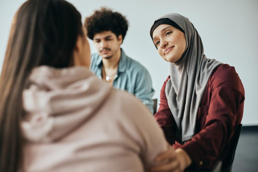 people in a group therapy session listen to another person talking about the next steps after rehab