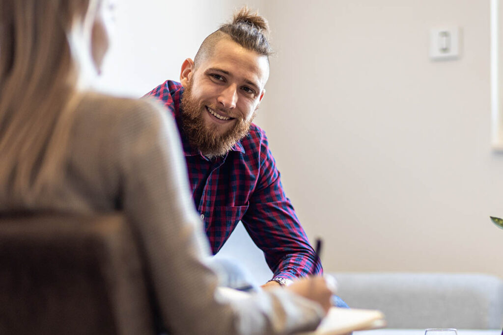 a man with a beard asks how to quit using cocaine to his therapist who is writing down notes