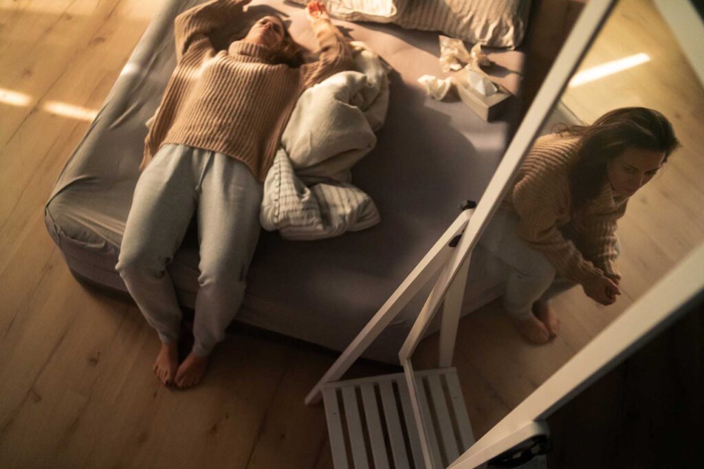 a woman lies on a bed after crying with used tissues and struggling with how to live with someone with a personality disorder