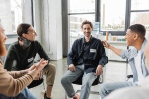 a group of people sit in a circle sharing resources for alcohol addiction recovery in Massachusetts