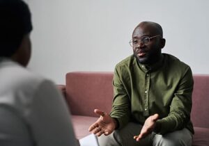 a young adult male looks to his therapist and talks to him about his concerns during his individual therapy program