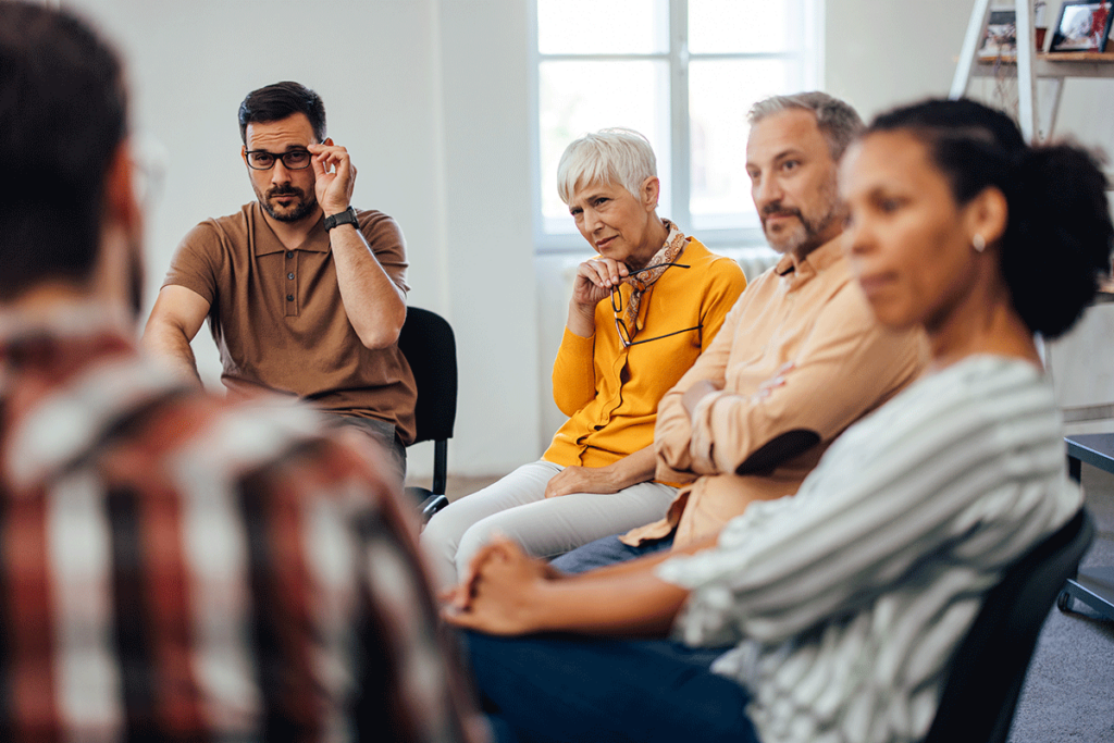 a group therapy is in session with people sitting in chairs and listen to the therapist discuss the benefits of intensive outpatient treatment