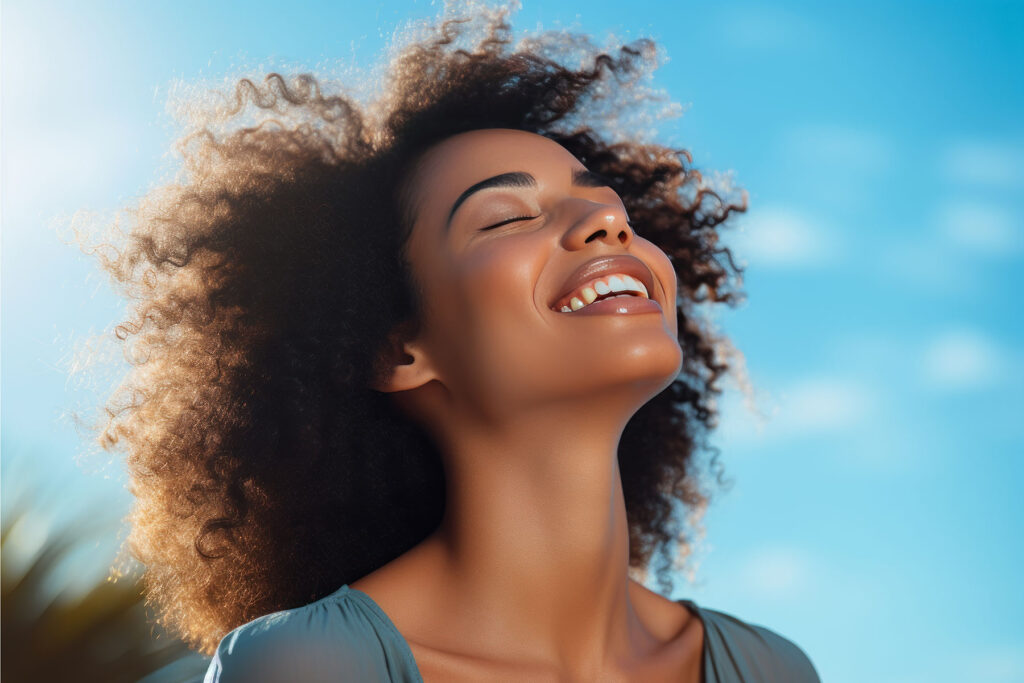 woman leans her head back and smiles while feeling good about her recovery goals