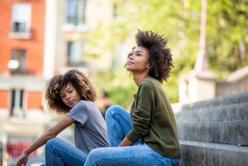 two woman sit outside and are discussing how cbt techniques have helped them in their addiction journey