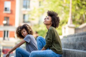 two woman sit outside and are discussing how cbt techniques have helped them in their addiction journey