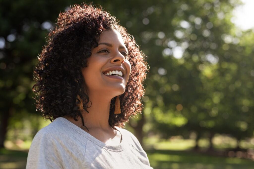 woman smiles while outside and wonders what california sober means