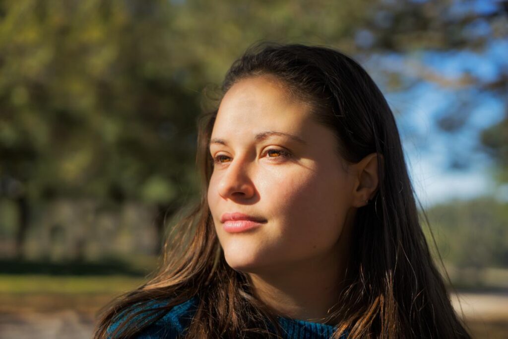 woman is outside and looking off into the distance asking herself what is narcissism